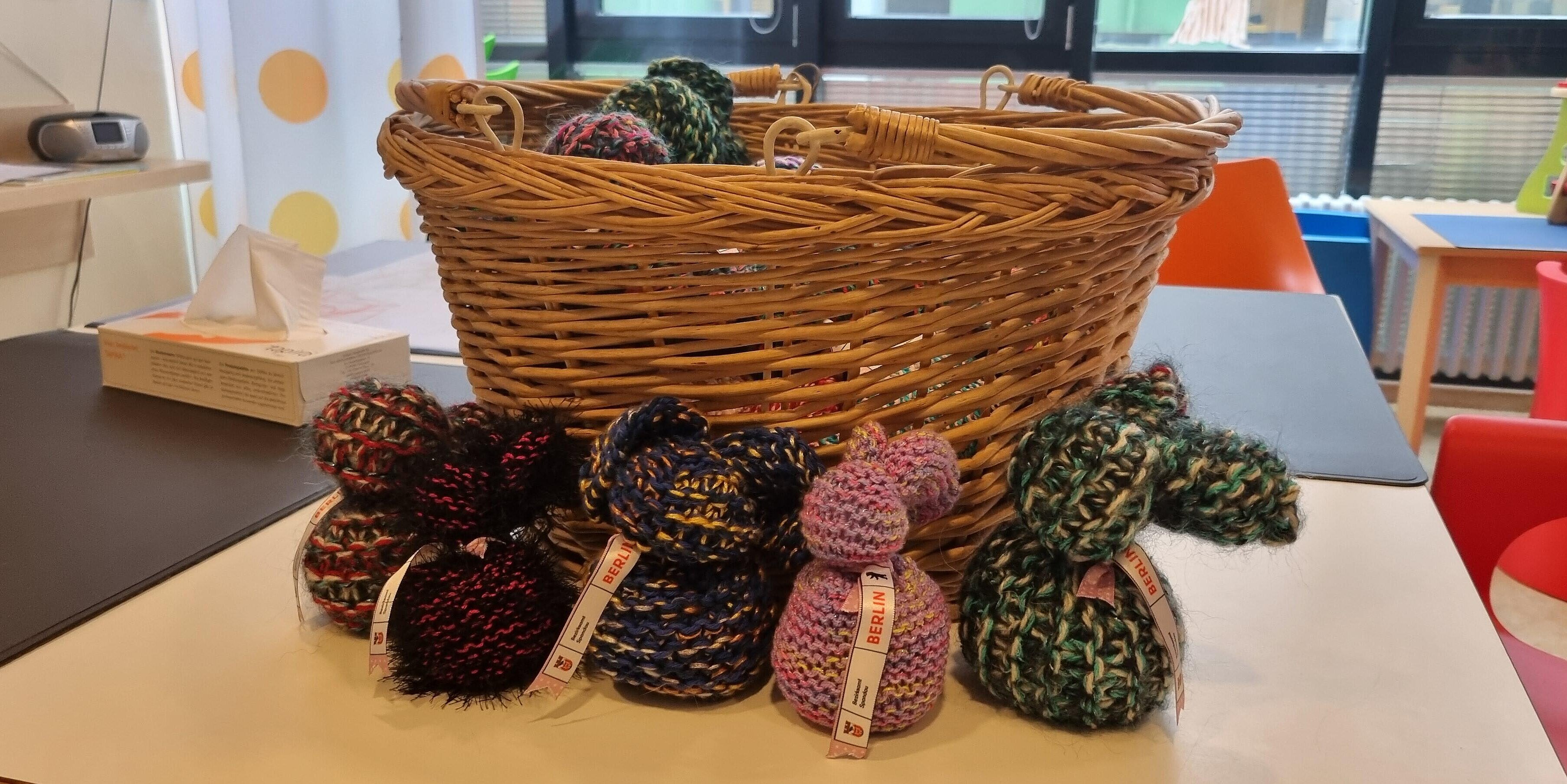 Kuschelige Osterhasen für die Kinderstation Osterhasen aus Wolle stehen vor einem Osterkörbchen