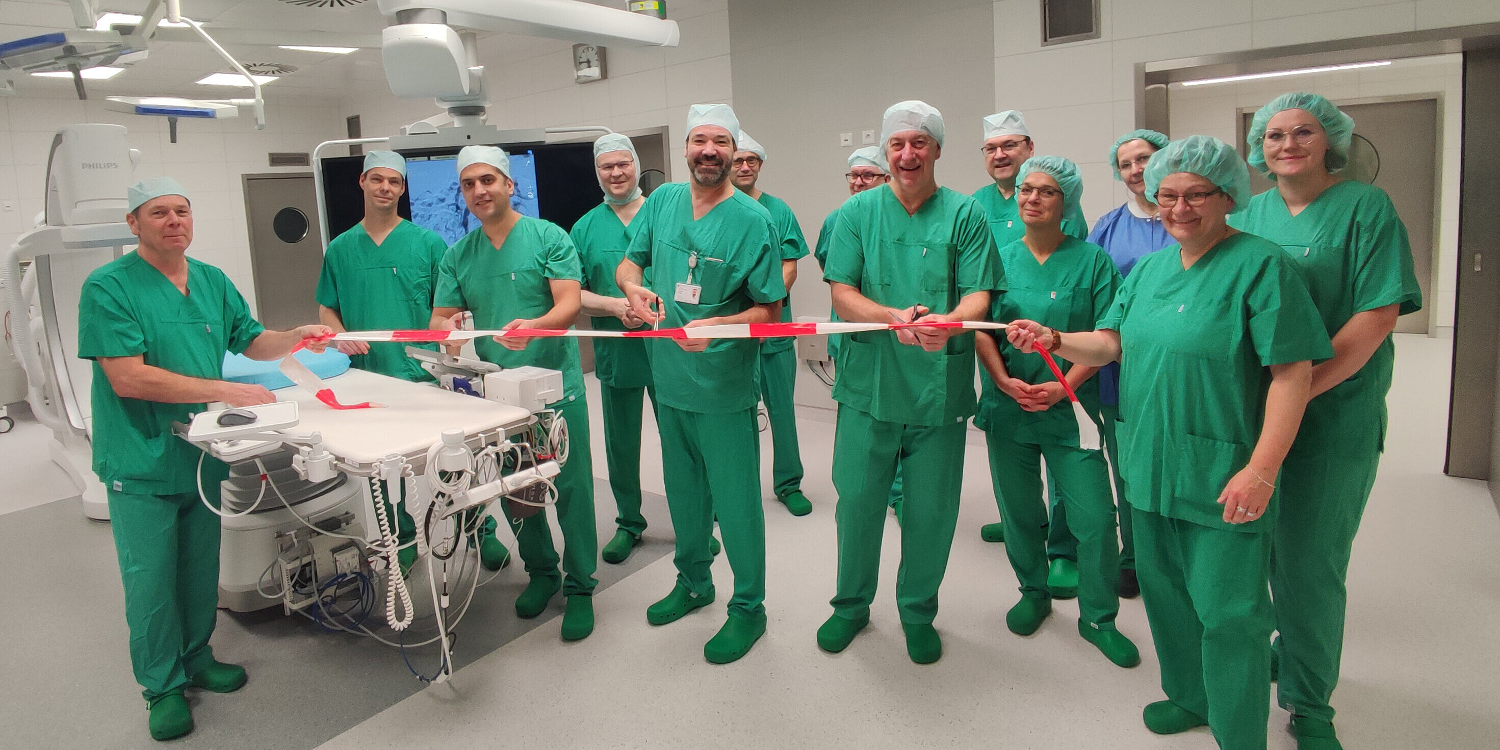 Teamwork im Hybrid-OP. Die Chefärzte Kareem El Sherbiny und Priv.-Doz. Dr. med. Torsten Röpke schneiden mit Geschäftsführer Matthias Lauterbach das Eröffnungsband durch.