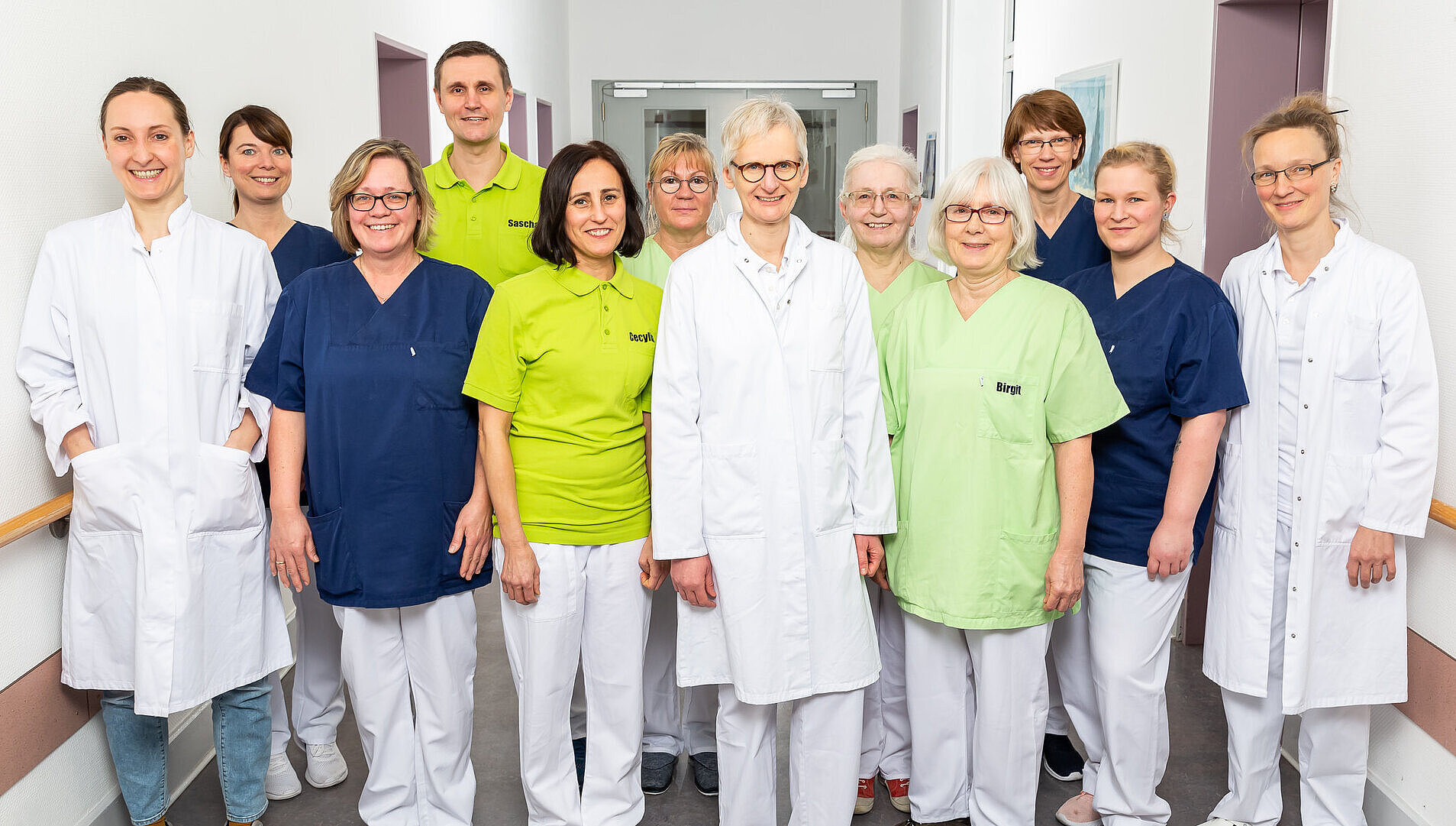Berufsübergreifende Zusammenarbeit in der Geriatrie Gruppenfoto des Tagesklinik-Teams im Flur des Krankenhauses.