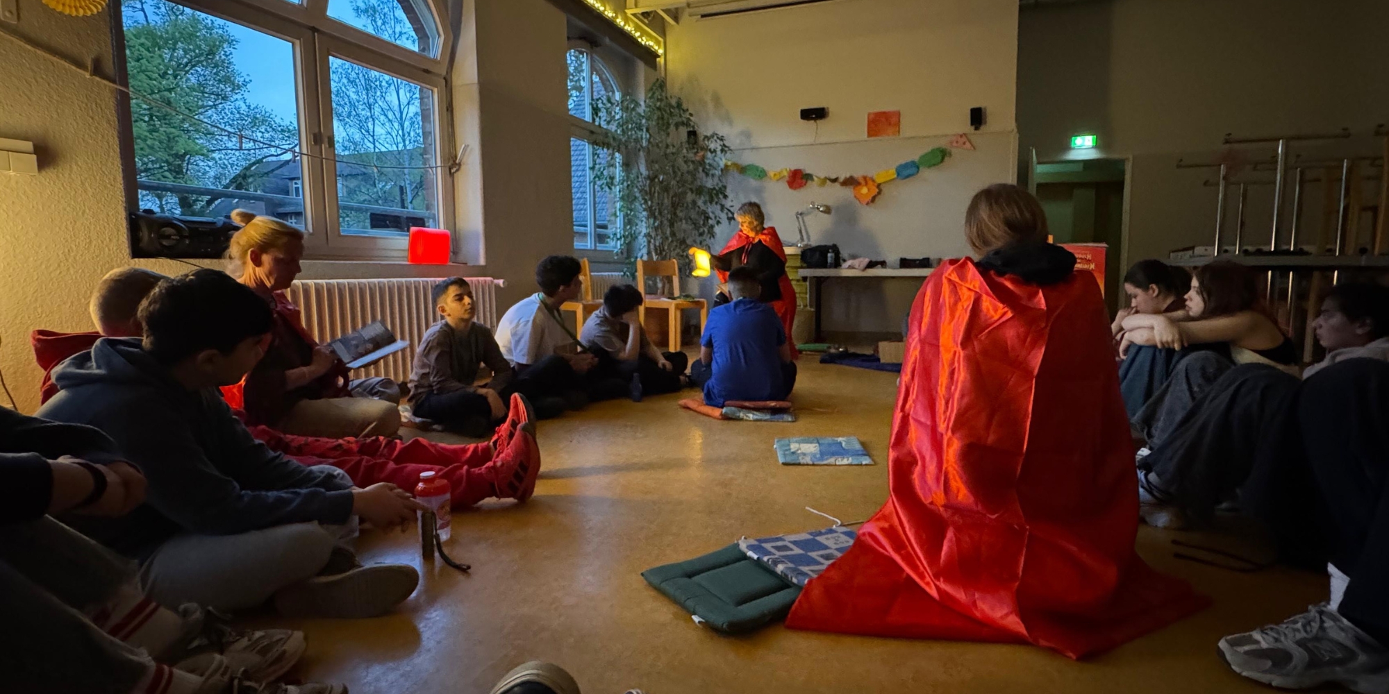 Wenn Lesen Mut macht: Ein Leseabenteuer über Mobbing und Superkräfte Kinder sitzen im Kreis und lauschen der Vorleserin